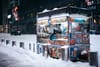 A Halal cart vendor reaches out of his cart during a snowstorm